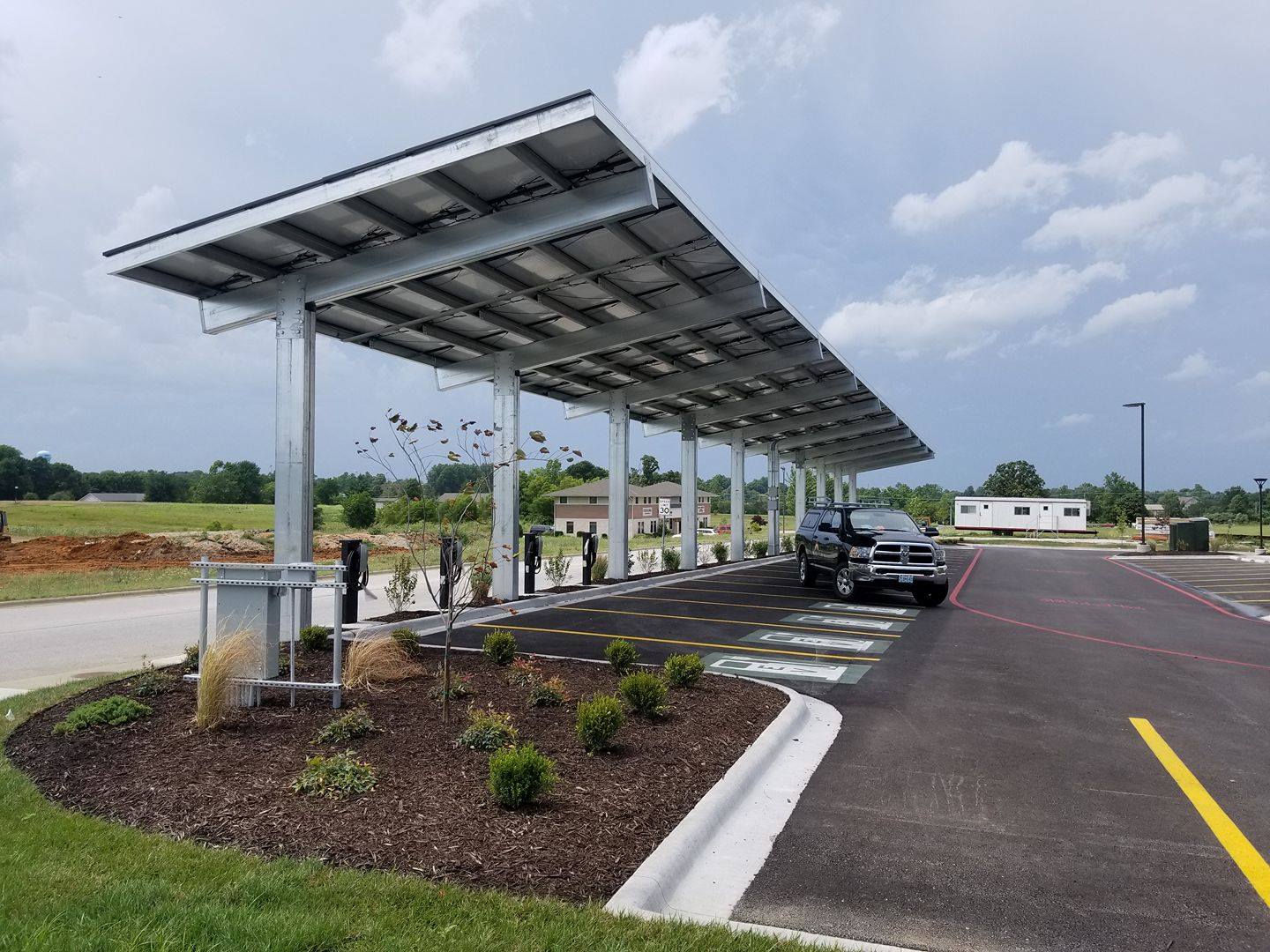 A solar-powered metal carport with electric car charging stations underneath at the Best Western in Bolivar, MO.