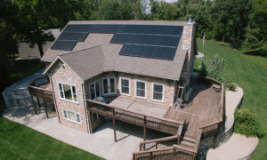 Residential home with solar panels on the sloped shingle roof