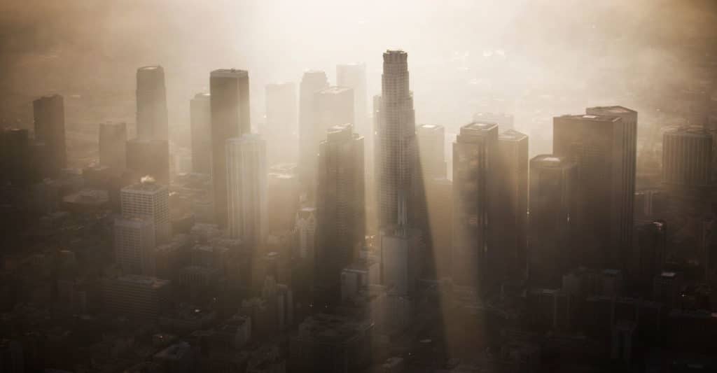 A city with heavy smog and pollution blurring the sky scrapers.